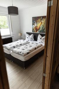 een slaapkamer met 2 bedden en een schilderij aan de muur bij Anil‘s Ferienhaus in Olsberg