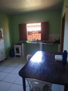 a kitchen with a table with chairs and a window at Casa de Veraneio in Salinópolis