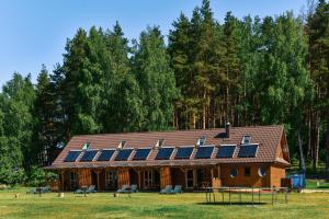 a house with solar panels on the roof at Duriu sodyba in Molėtai