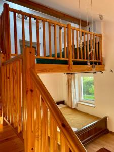eine Holztreppe in einem Haus mit Fenster in der Unterkunft Zacisze na Podzamczu in Odrzykoń