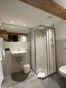 a bathroom with a glass shower and a sink at Ferienwohnung Florina in Galtür