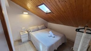 una camera con un letto bianco e un lucernario di Apartamento rural en Espinosa de los Monteros a Espinosa de los Monteros