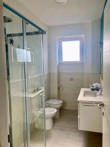 La salle de bains est pourvue d'une douche, de toilettes et d'un lavabo. dans l'établissement Appartamento Tizzy, à La Maddalena