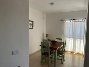 a dining room with a table and chairs and a window at Aires del estero 2 in Santiago del Estero