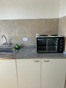 a kitchen counter with a microwave and a sink at Aires del estero 2 in Santiago del Estero