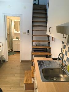 a kitchen with a sink and a spiral staircase at Apartma BAUI Koper in Koper