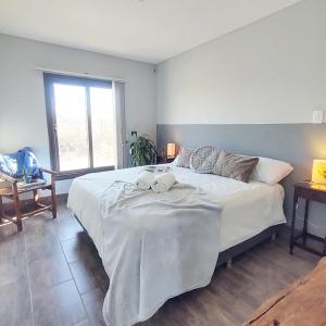 um quarto com uma grande cama branca com toalhas em Tomero Apartamento em Tupungato