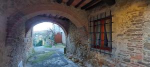 an archway in an old stone building with a window at La Casina in Fornello
