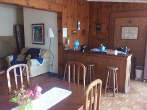 ein Wohnzimmer mit einem Tisch und einer Bar in der Unterkunft Casa Green Vista in Campos do Jordão
