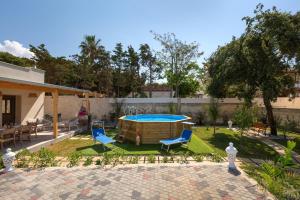 un patio trasero con piscina, 2 sillas y una mesa en Villa Althea by BarbarHouse, en San Pietro in Bevagna