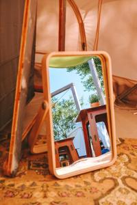 a mirror with a reflection of a house in it at DOMO CAMP Sylt - Glamping Camp in Westerwall