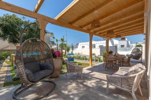 a porch with chairs and a swing and a table at Villa Althea by BarbarHouse in San Pietro in Bevagna
