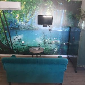 a living room with a large painting of a waterfall at Casa de Bairros in Soajo