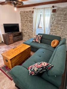 a living room with a blue couch and a tv at Casa Stella in Draguć