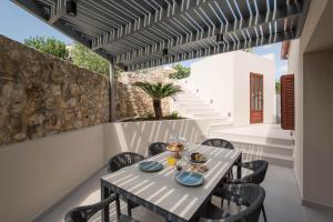 uma sala de jantar exterior com mesa e cadeiras em Villa Methexis em Arménoi