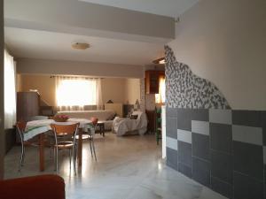 Il comprend une cuisine et un salon avec une table et des chaises. dans l'établissement Maria’s House Kineta, à Mégare
