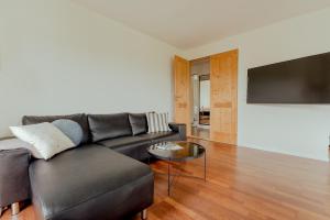 ein Wohnzimmer mit Sofa und Tisch in der Unterkunft Marina view - 3 Bedroom Apartment - Central Tórshavn in Tórshavn