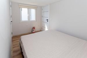 a white bedroom with a bed and a window at Termessos Villa's in Dosemealti