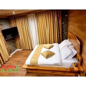 1 cama con sábanas blancas y almohadas en una habitación en Bujtina Ajazi, en Golem