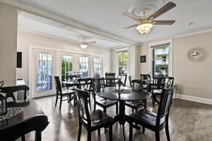 a dining room with tables and chairs and windows at The Inn at Ocean Grove in Ocean Grove