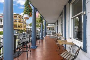 - un balcon avec des tables et des chaises dans un bâtiment dans l'établissement The Inn at Ocean Grove, à Ocean Grove