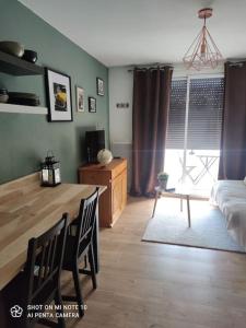 Beau studio cabine cozy في شامروس: غرفة معيشة مع طاولة طعام وغرفة معيشة مع أريكة