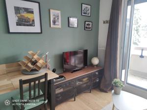 sala de estar con mesa y TV en Beau studio cabine cozy, en Chamrousse