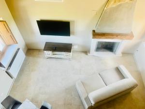 a living room with a white couch and a tv at Il Rifugio Del Certosino in Padula