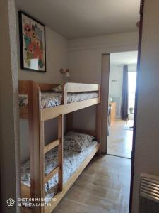 a room with two bunk beds and a mirror at Beau studio cabine cozy in Chamrousse
