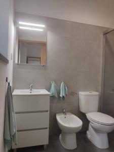 a white bathroom with a toilet and a sink at Quinta das Bicas AL in Angra do Heroísmo