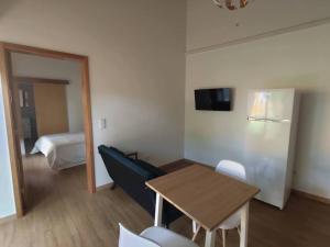 a room with a table and a refrigerator and a bed at Quinta das Bicas AL in Angra do Heroísmo