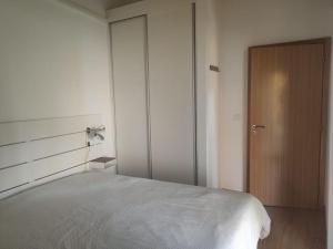 a bedroom with a bed and a wooden door at Quinta das Bicas AL in Angra do Heroísmo