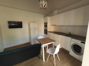 a small kitchen with a table and a couch at Quinta das Bicas AL in Angra do Heroísmo