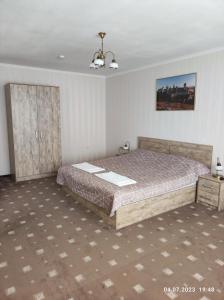 1 dormitorio con 1 cama grande en una habitación en Apart-hotel 24/7, en Kamianets-Podilskyi
