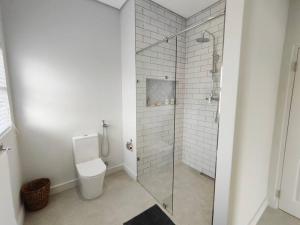 ランゲバーンにあるGolfers Haven Studio Apartmentのバスルーム(トイレ、ガラス張りのシャワー付)