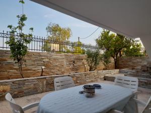 墨伽拉的住宿－Maria’s House Kineta，白色的桌子、白色的椅子和石墙
