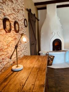 a lamp on a wooden table in front of a fireplace at Inside, The Village- Atelier in Tunari