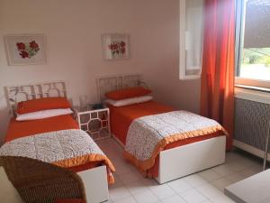 een slaapkamer met twee bedden en een raam bij Villa Degli Olivi in Pula