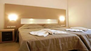 ein großes Bett mit zwei weißen Handtüchern drauf in der Unterkunft Zorbas Hotel in Georgioupoli