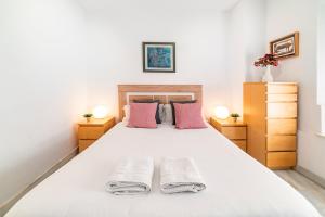 a bedroom with a large white bed with two night stands at AlohaMundi Almansa in Seville