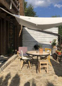 patio con tavolo, sedie e ombrellone di Kostovac Boutique Homes - Apartment with Sauna a Kopaonik
