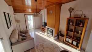 a living room with a couch and a tv at Casa Avô Nino in Nazaré