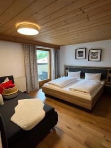 a bedroom with a large bed and a couch at Ferienwohnung Florina im Hotel Casada in Galtür