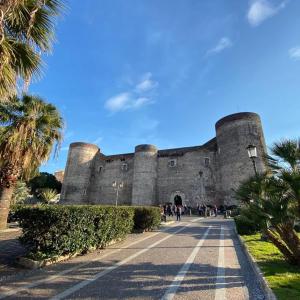 a large castle with people walking in front of it at Borgo Santa Caterina in Catania