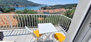 a table and chairs on a balcony with a view at Bjelopera Rooms in Zaton