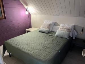 a bed in a room with purple and white walls at Le chalet Normand in Merville-Franceville-Plage