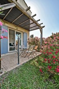 patio z krzesłami, stołem i kwiatami w obiekcie LE PETIT BONHEUR - PLACE PARKING PRIVEE - CLiM - TERRASSE - PISCINE PARTAGEE - PROCHE PARC SPIROU w mieście Saint-Saturnin-les-Avignon