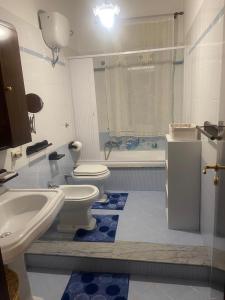 La salle de bains est pourvue de toilettes, d'un lavabo et d'une baignoire. dans l'établissement Appartamento via Roma, à Siculiana