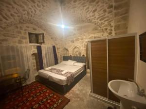 ein Schlafzimmer mit einem Bett und einem Waschbecken in einem Gebäude in der Unterkunft Gılgamesh butik otel in Mardin