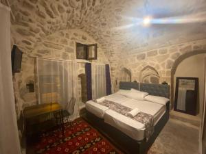 馬爾丁的住宿－Gılgamesh butik otel，石头间内一间卧室,配有一张床